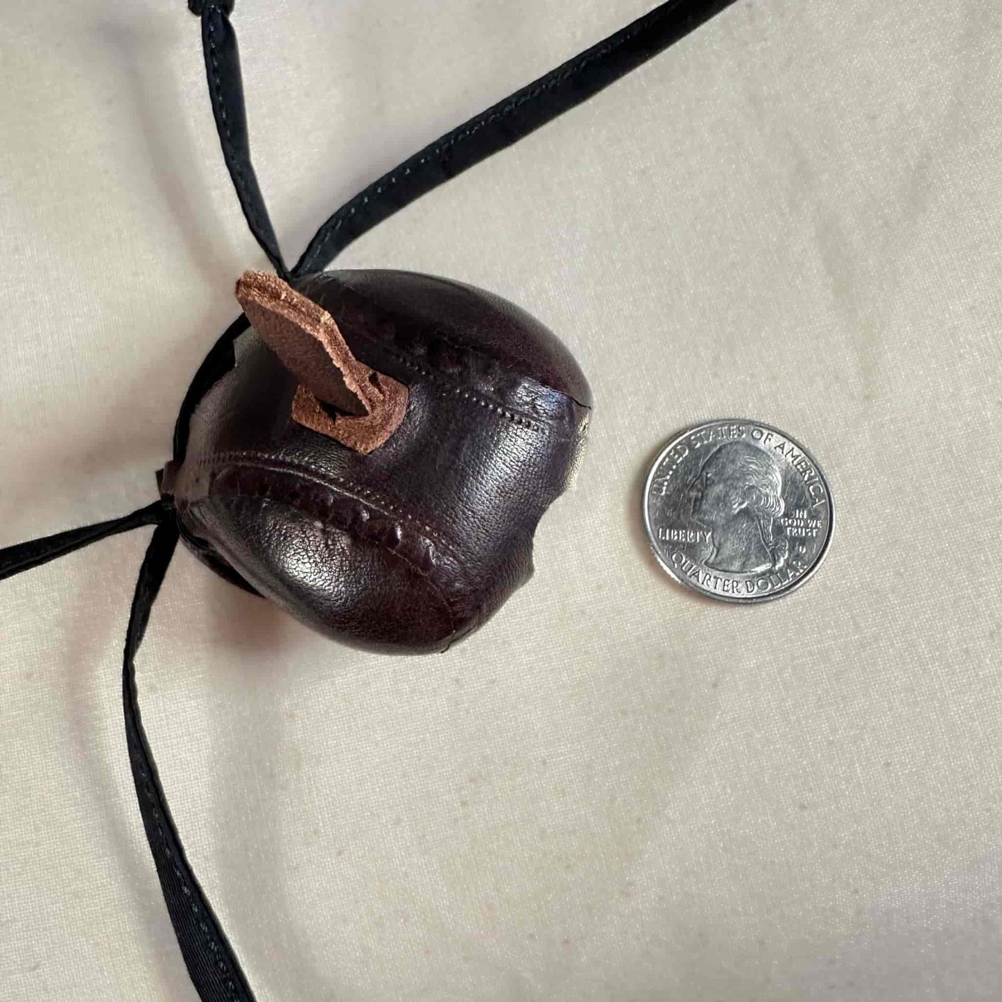 Mini falcon hood made of brown kangaroo leather with a top ornament looking from above.