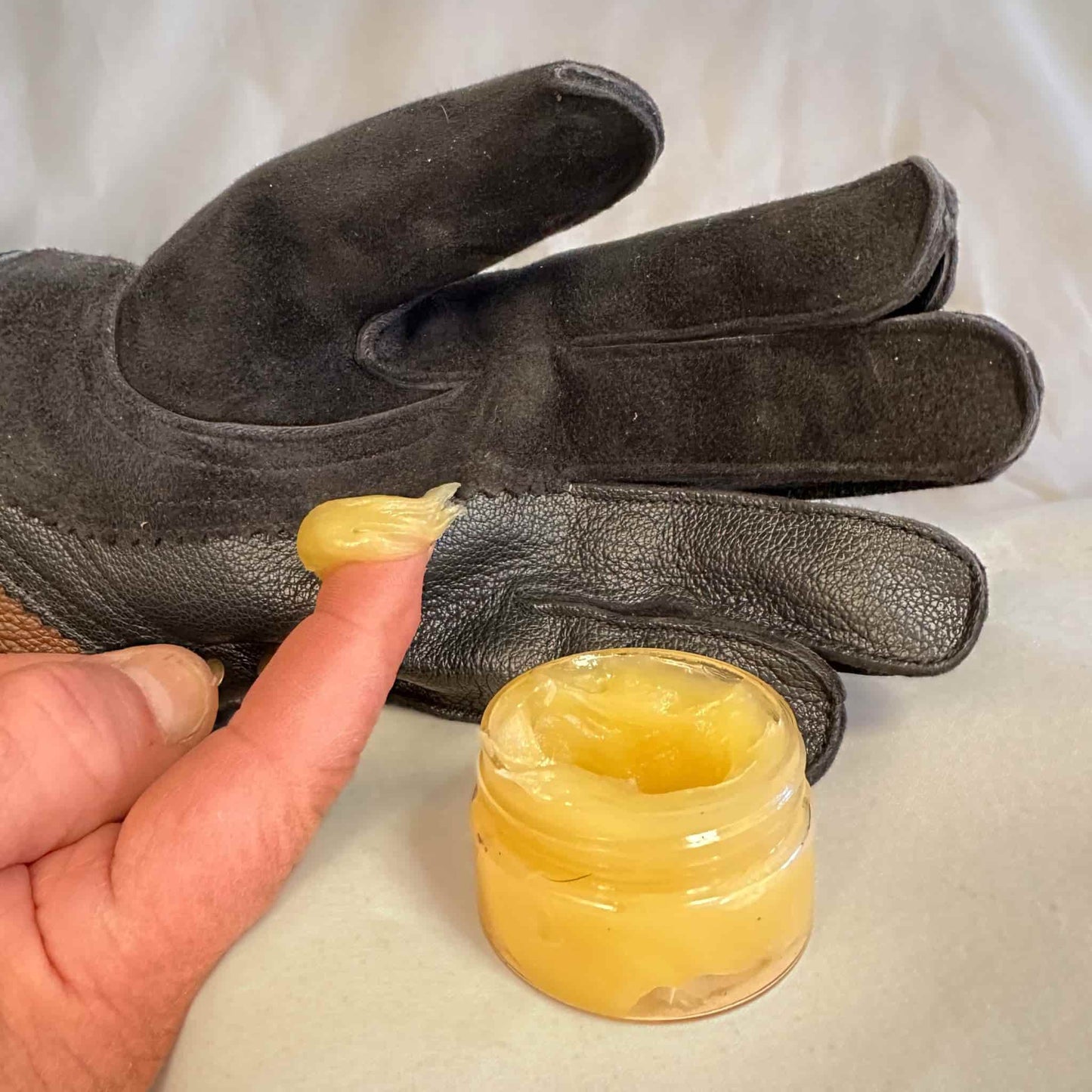 A photo of 1 ounce jar of Montana Brand leather dressing gauntlet oil which is included with each glove purchased