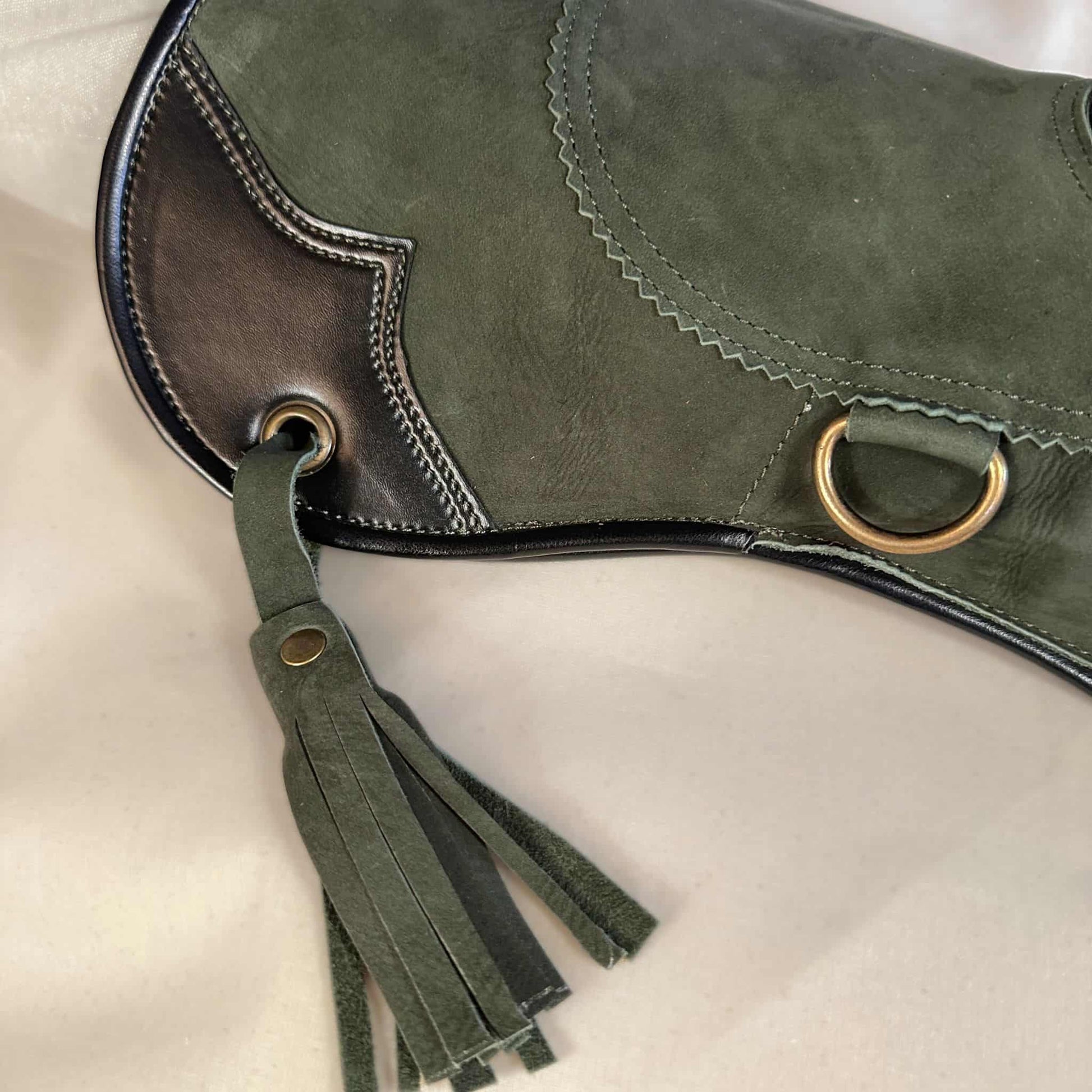 A Forest Green Full-Cuff long falcon gauntlet made with Calf Leather looking at a detailed view of the cuff and tassel.