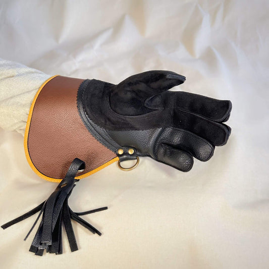 A short half-cuff falcon gauntlet made with brown and black suede deer leather looking at the palm. 