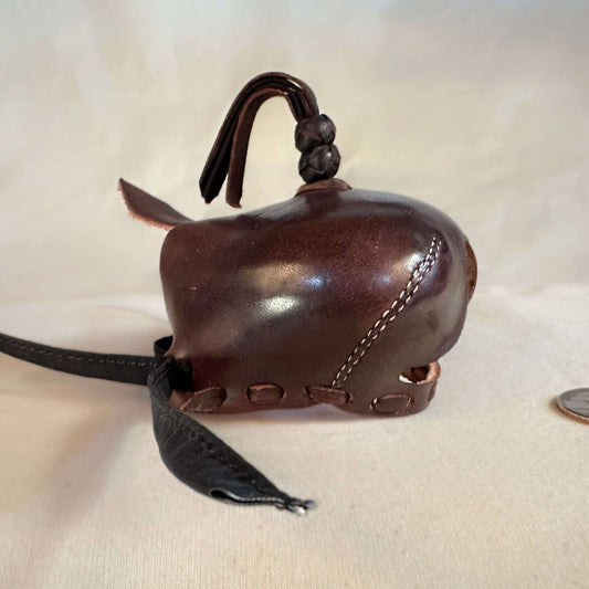 Falcon hood made of brown calf leather with a double knot top ornament in a right side view.