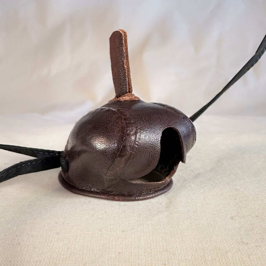 Mini falcon hood made of brown kangaroo leather with a top ornament looking at a three-quarter view.