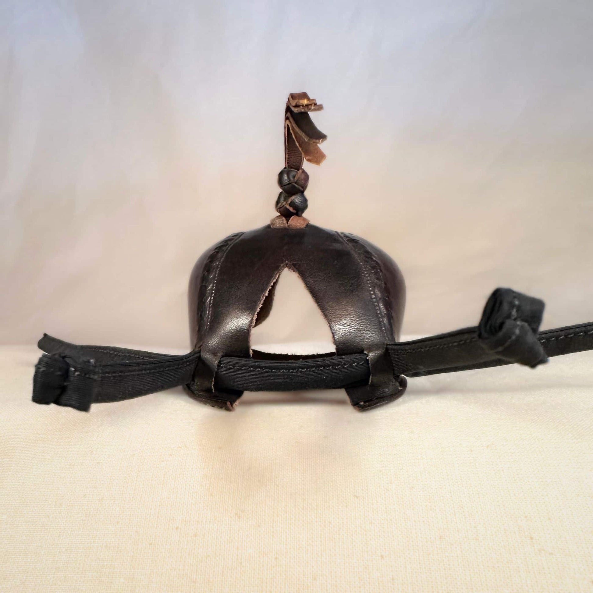 Falcon hood made of two-tone brown calf leather with a double knot top ornament from the back.