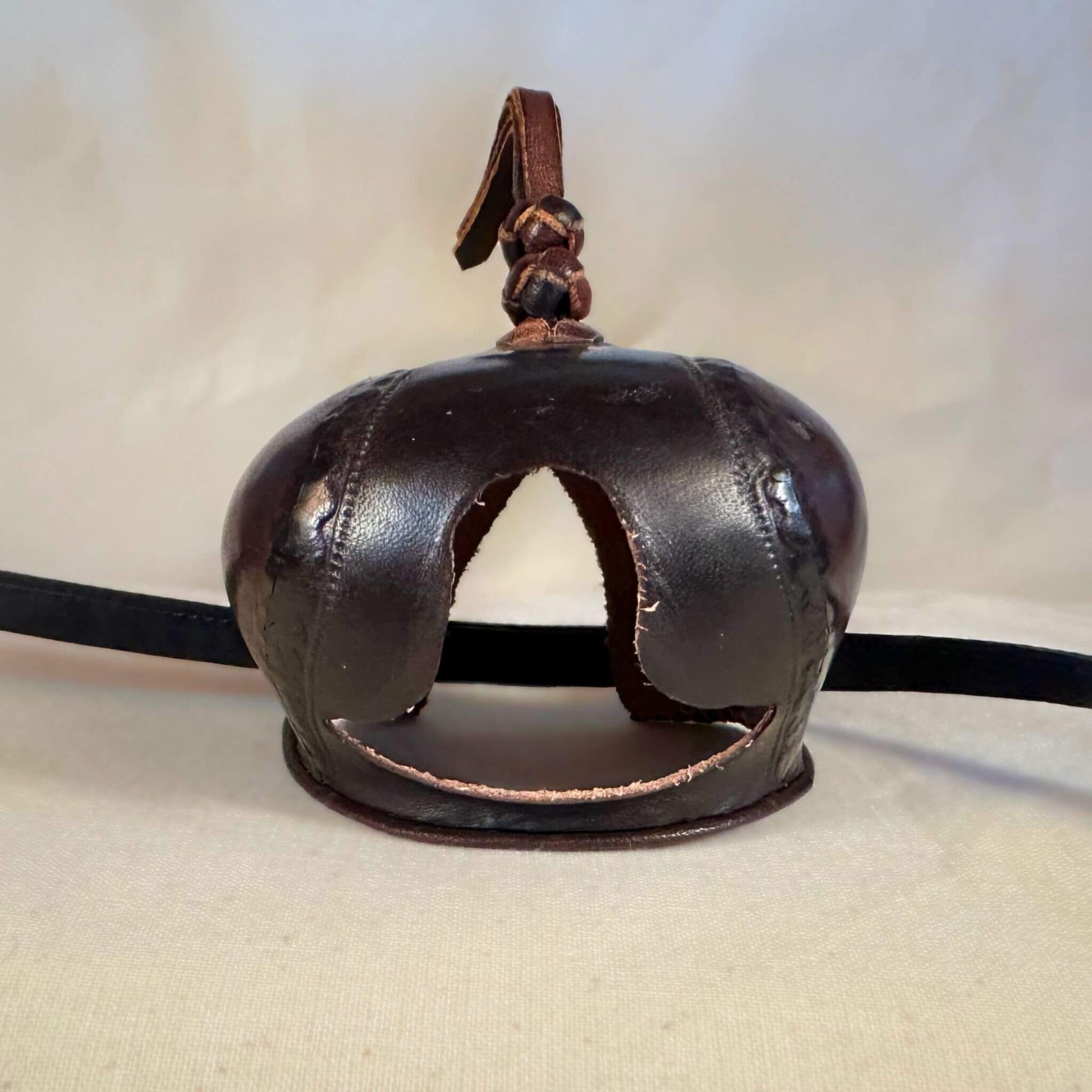 Falcon hood made of two-tone brown calf leather with a double knot top ornament from the front.
