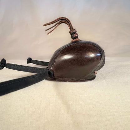 Falcon hood made of two-tone brown calf leather with a double knot top ornament in a right-side view.