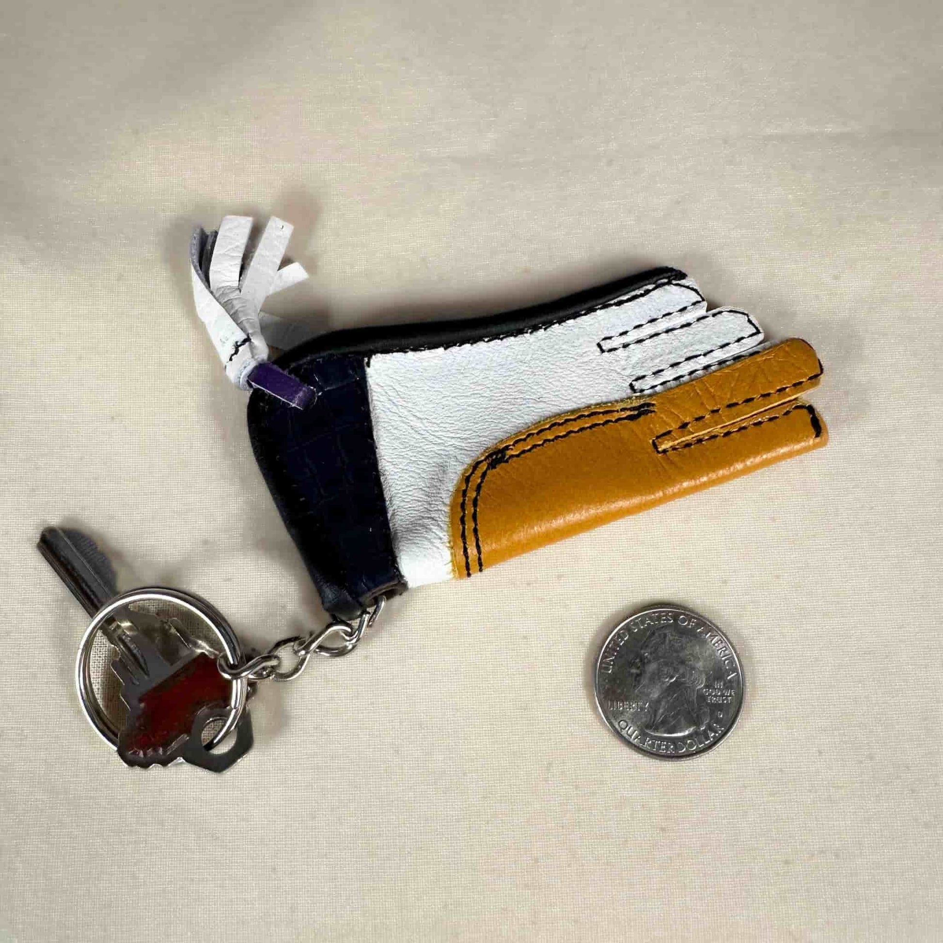 Miniature sewn gauntlet with a key ring showing the back.