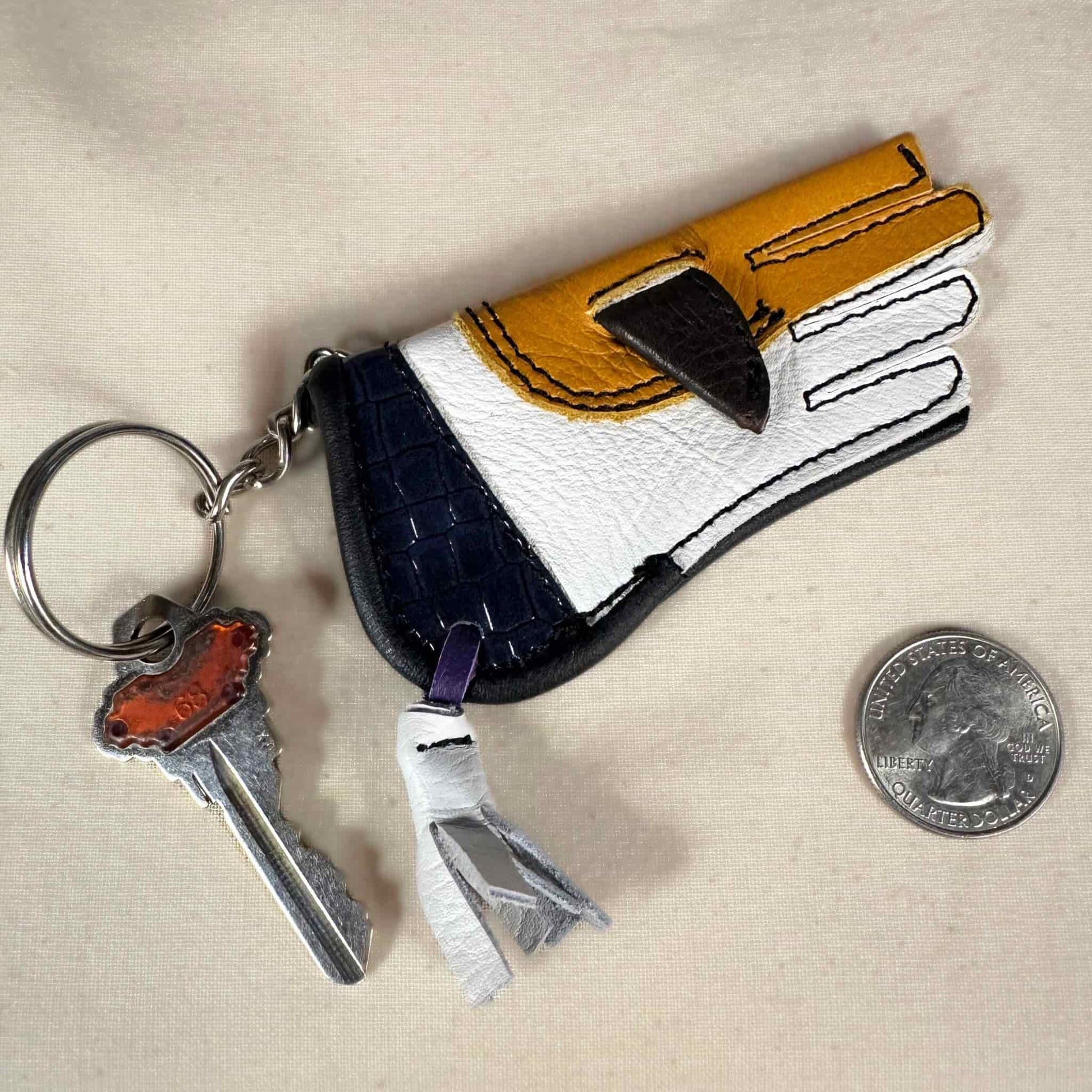 Miniature sewn gauntlet with a key ring showing the front.