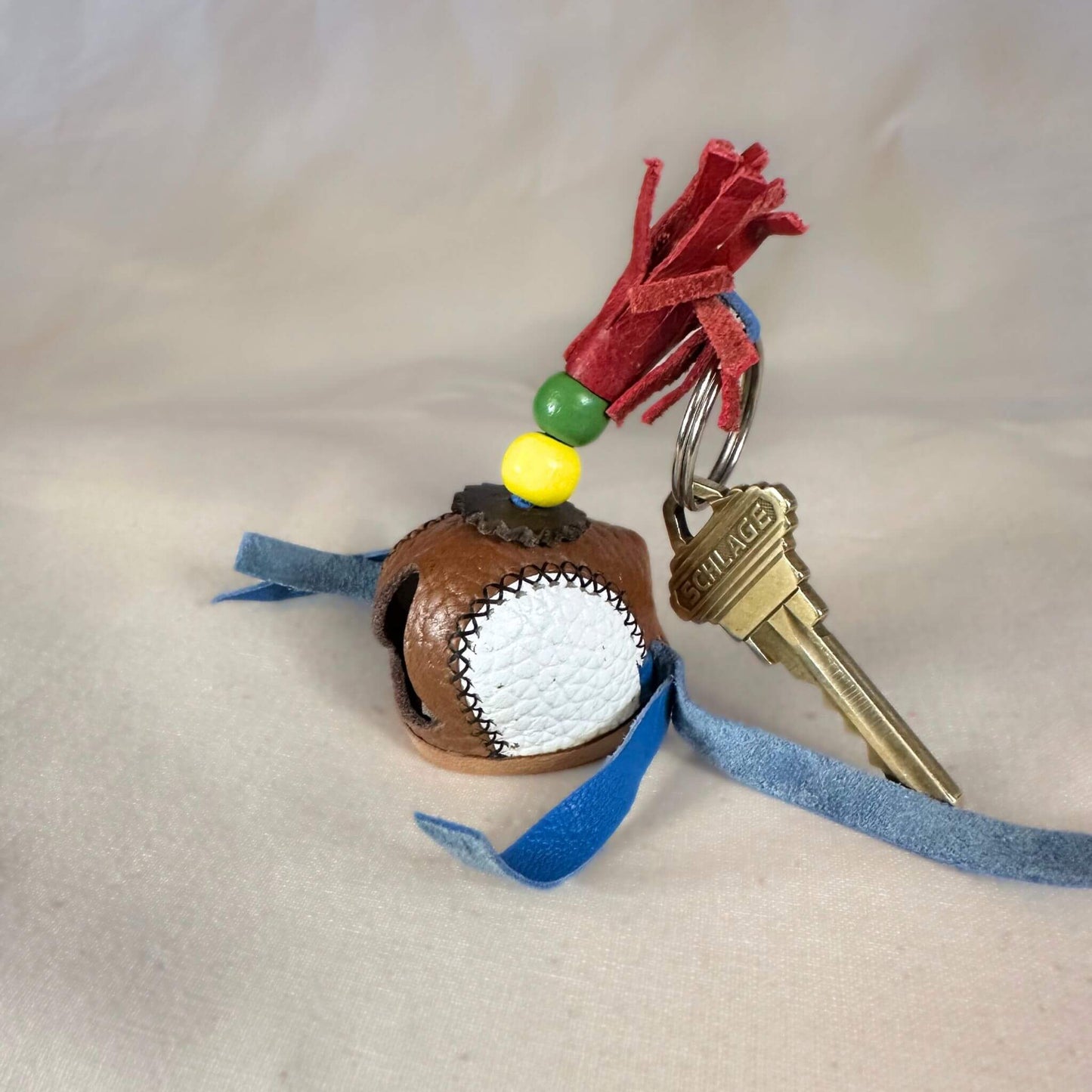 Miniature sewn hood with a key ring from the left side.